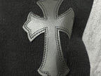 Black sweater with silver-tone cross applique with stitched edges