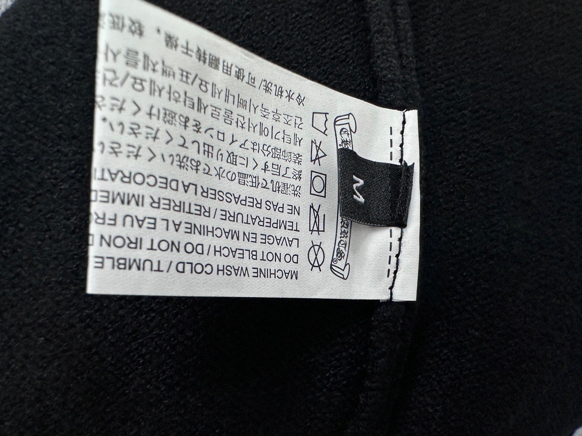 Black knit sweater garment label sewn at inside neckline
