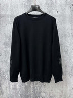 Black long-sleeve knit sweater with ribbed crew neck and cuffs