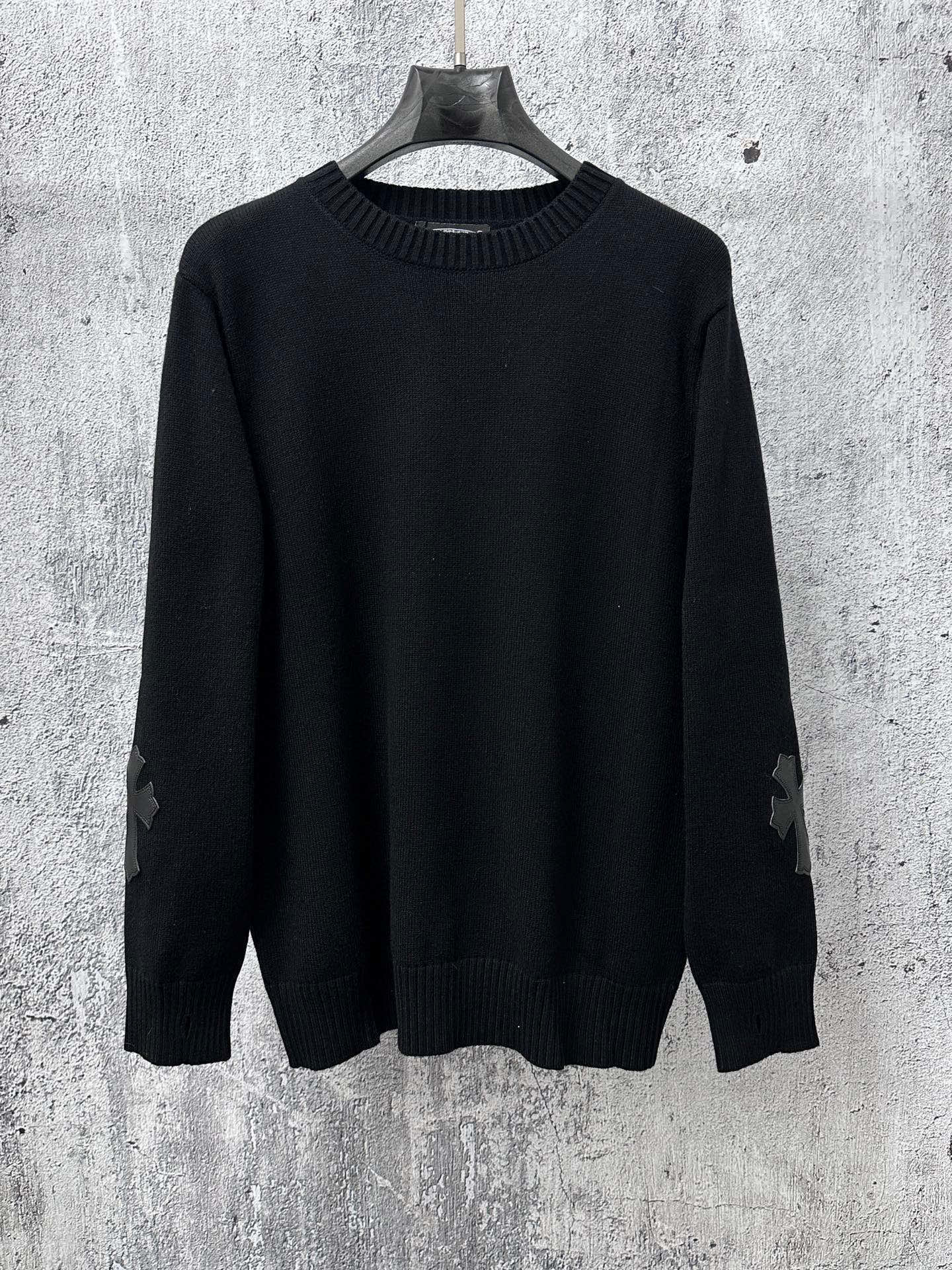 Black long-sleeve knit sweater with ribbed crew neck and cuffs