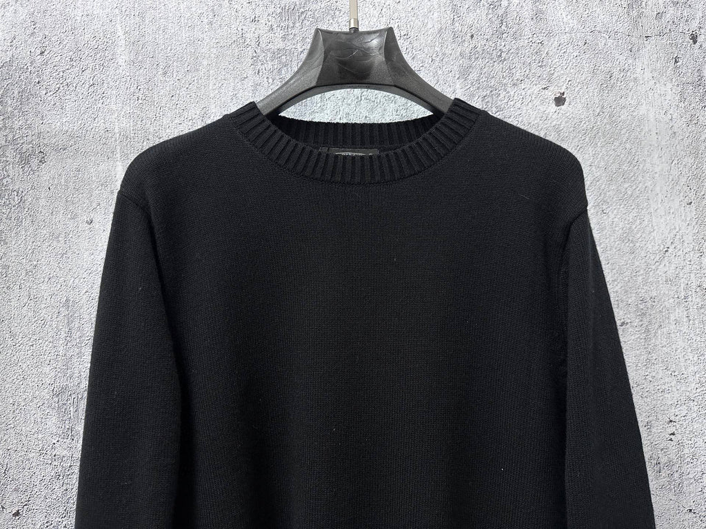 Black long-sleeve knit sweater with ribbed crew neck collar