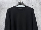 Black long-sleeve knit sweater with ribbed crew neck collar