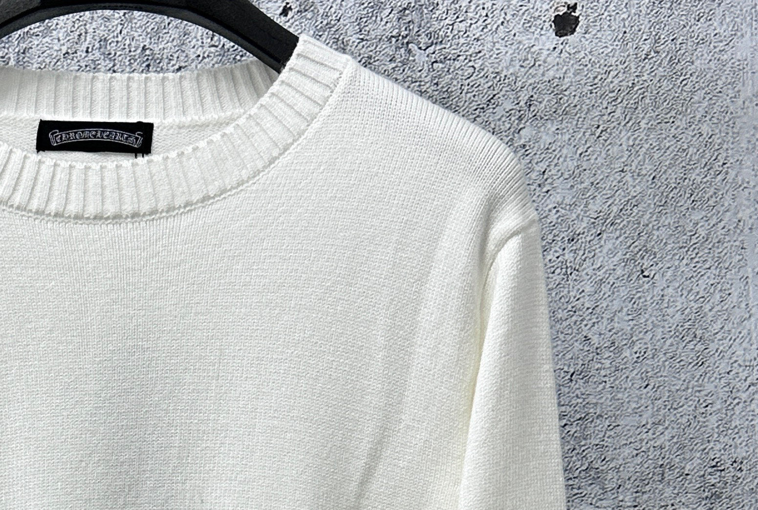 Light long-sleeve sweater neckline with black brand tag