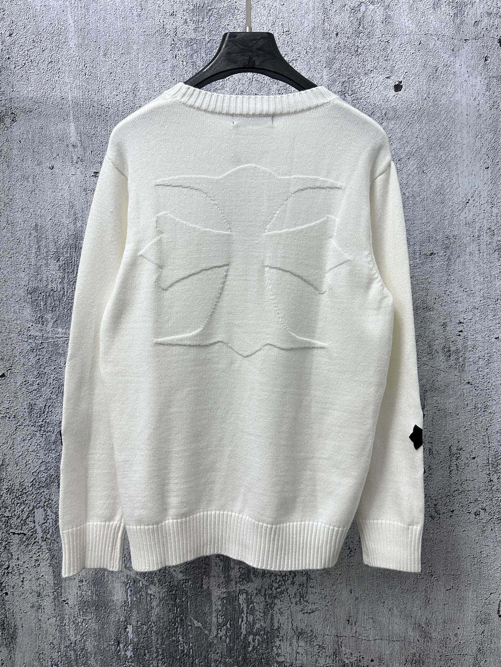 Light long-sleeve sweater with large stitched cross graphic on back
