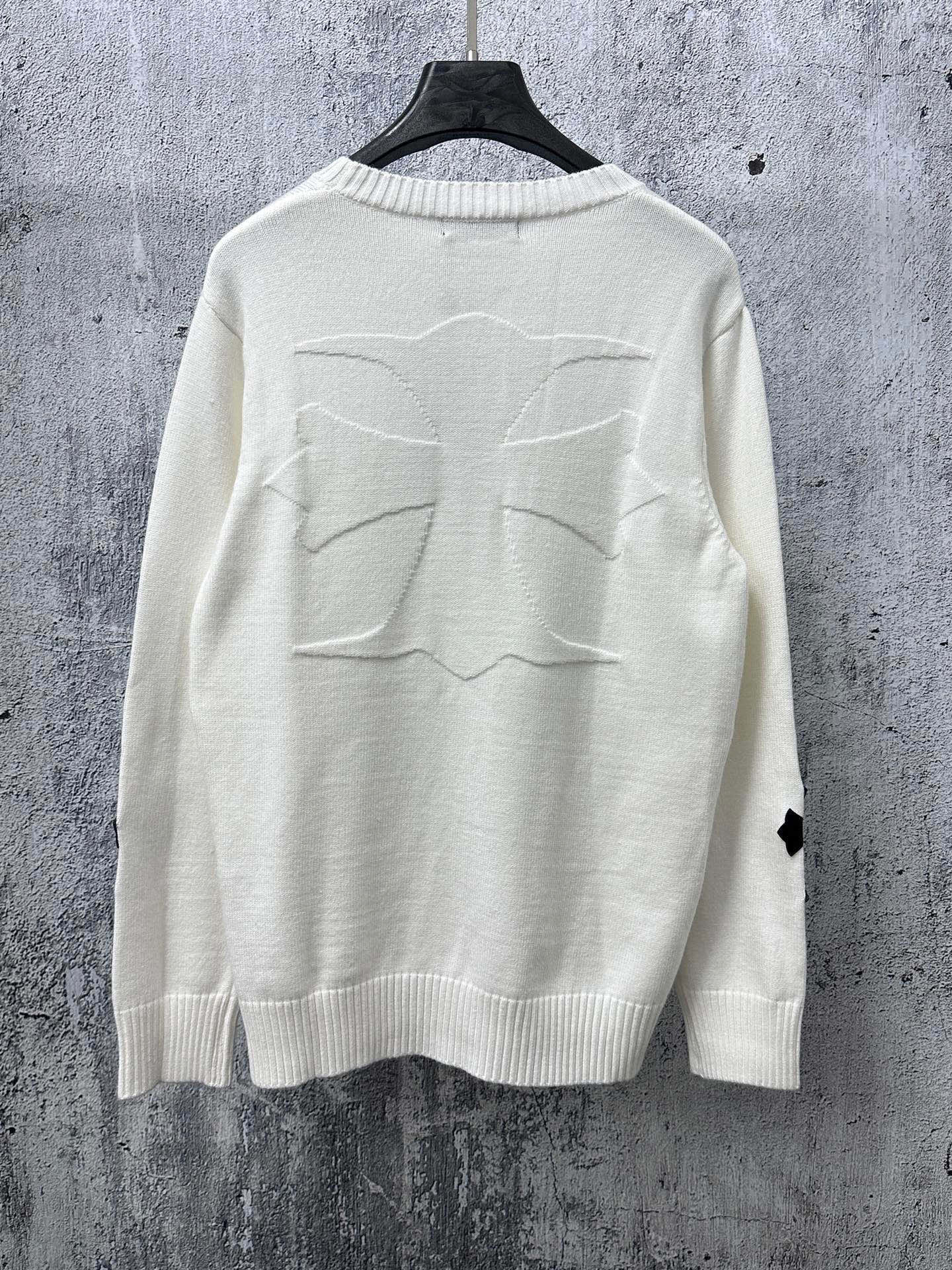 Light long-sleeve sweater with large stitched cross graphic on back