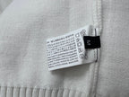 Light sweater fabric care label sewn inside neck