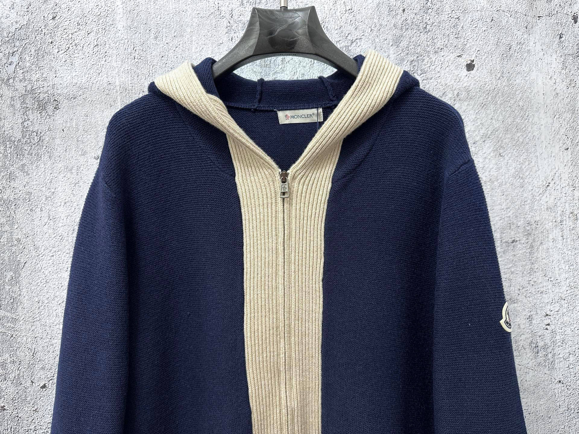 Moncler long navy knit hoodie front view with cream ribbed hood and zipper