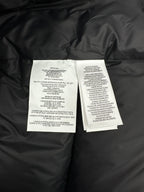 Dark puffer jacket interior with care label tags