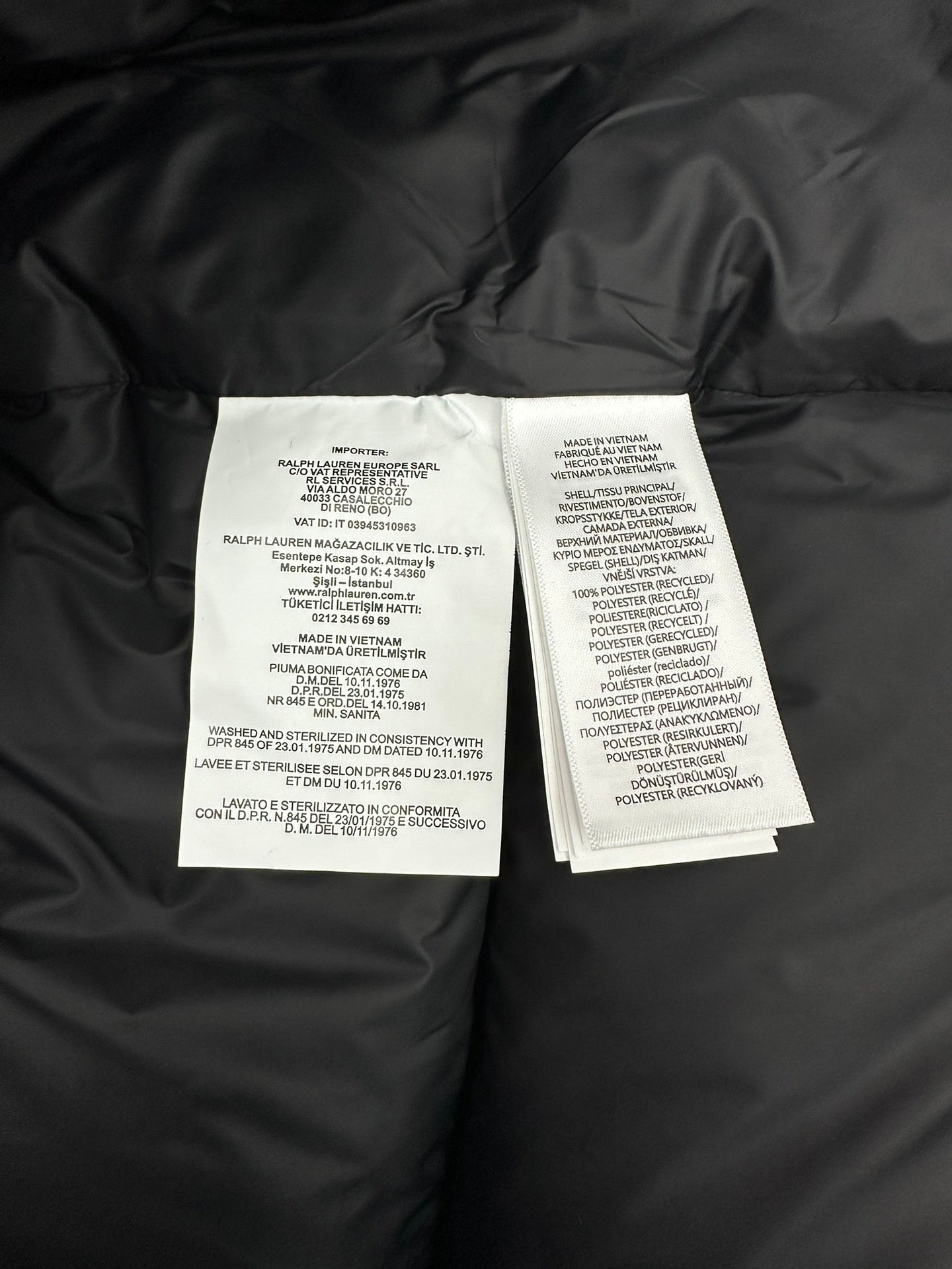 Dark puffer jacket interior with care label tags