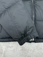 Dark puffer jacket sleeve cuff close-up with elastic hem and zipper trim