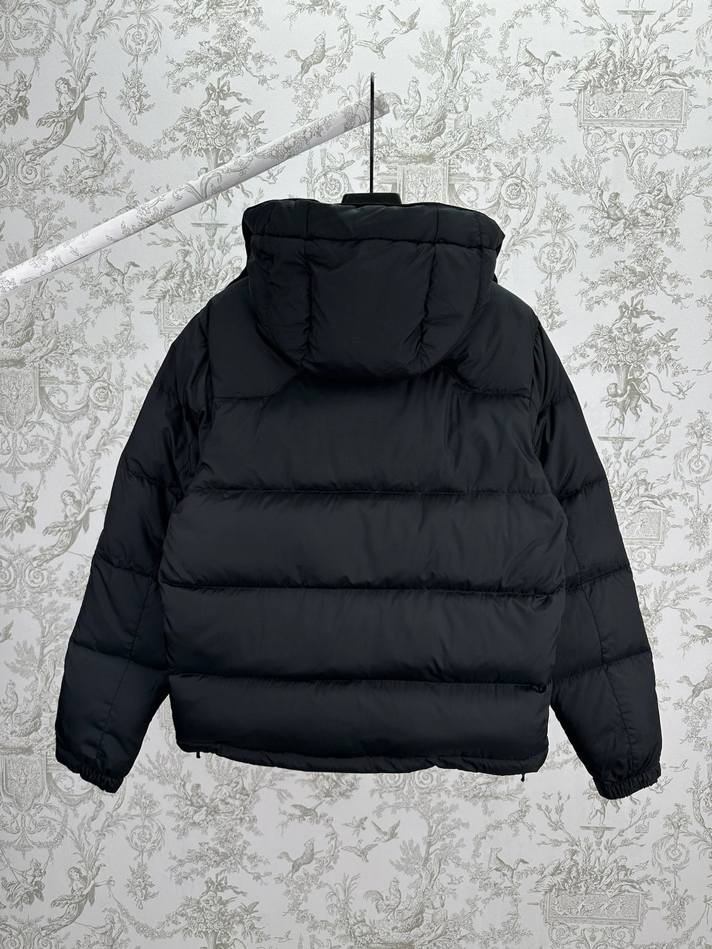 Dark hooded puffer jacket, full-zip front, back view with quilted panels
