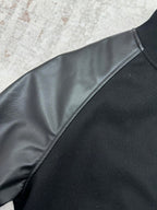 Black bomber jacket with dark faux-leather sleeve panel and contrasting trim