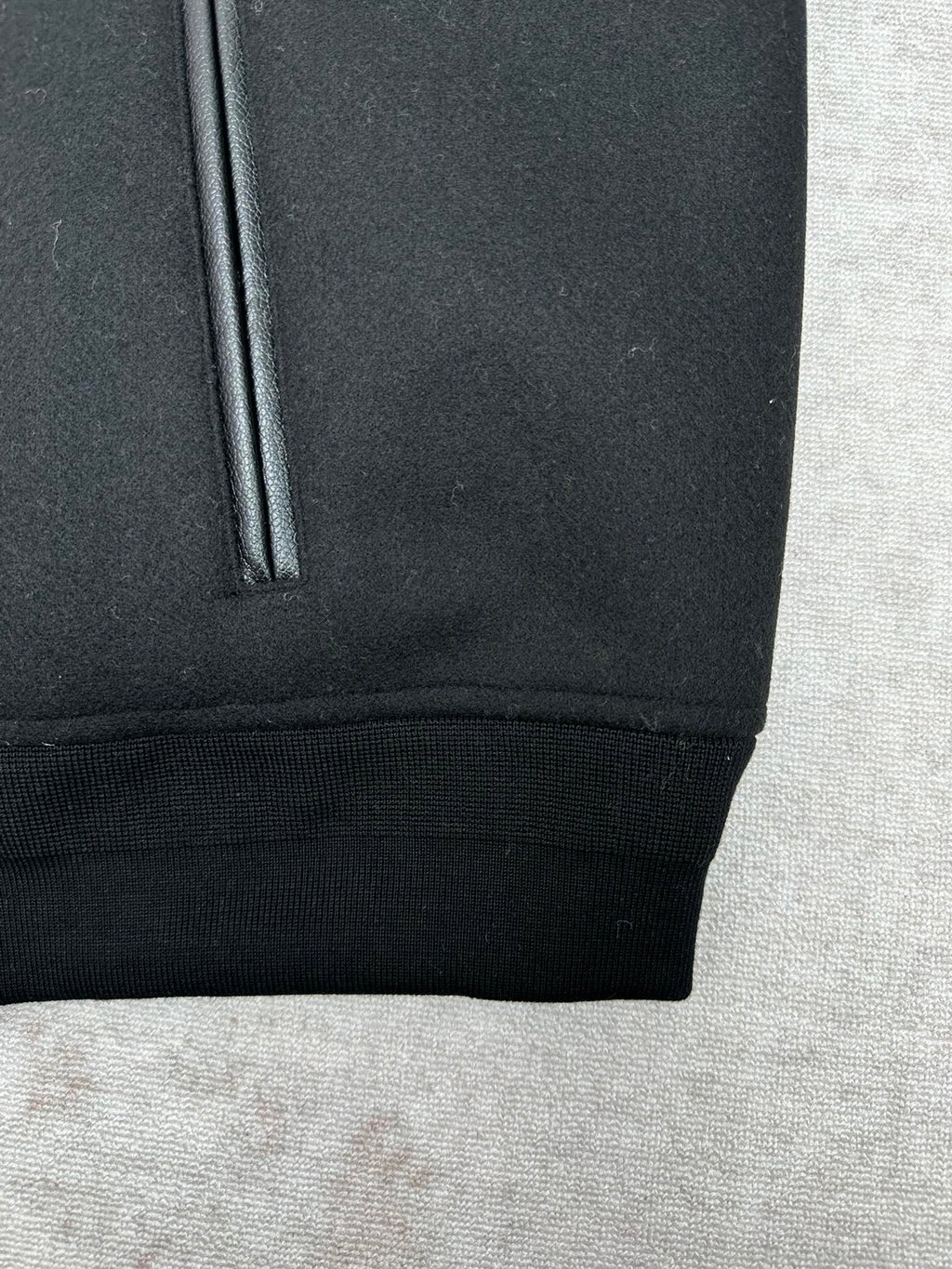 Black bomber jacket with ribbed hem and side pocket opening