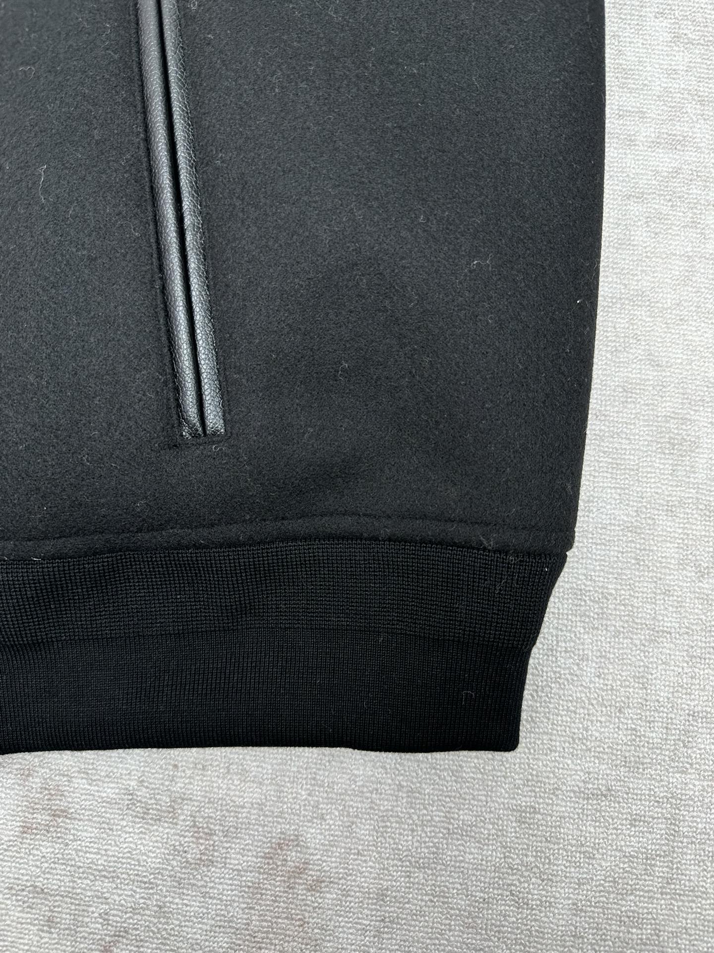 Black bomber jacket with ribbed hem and side pocket opening