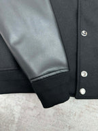 Black bomber jacket sleeve with ribbed cuff and silver snap buttons