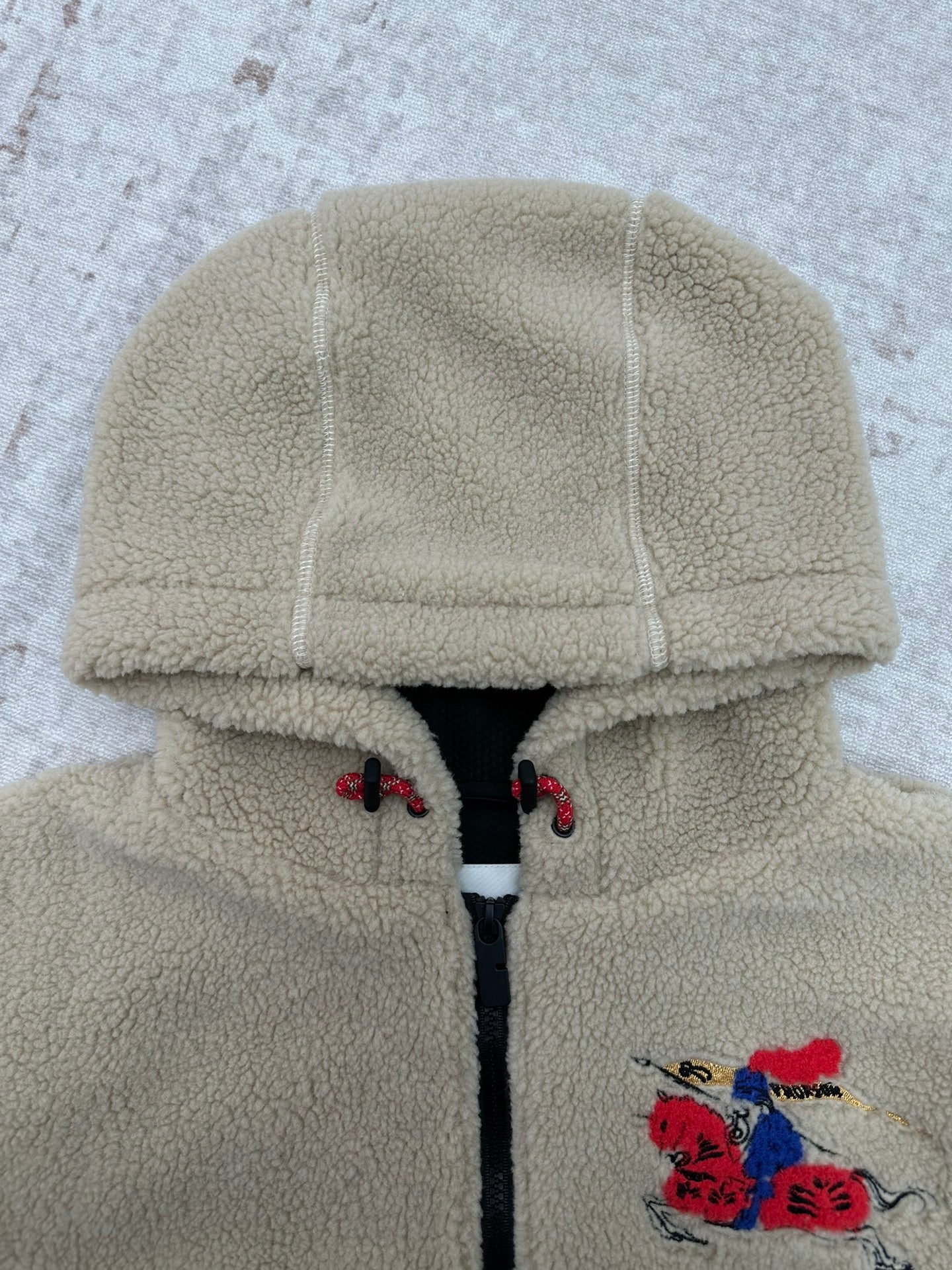 Burberry hooded sherpa jacket with cream fleece texture, front zipper and embroidered placket