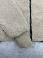 Cream sherpa jacket sleeve cuff with ribbed elastic trim and dark zipper edge