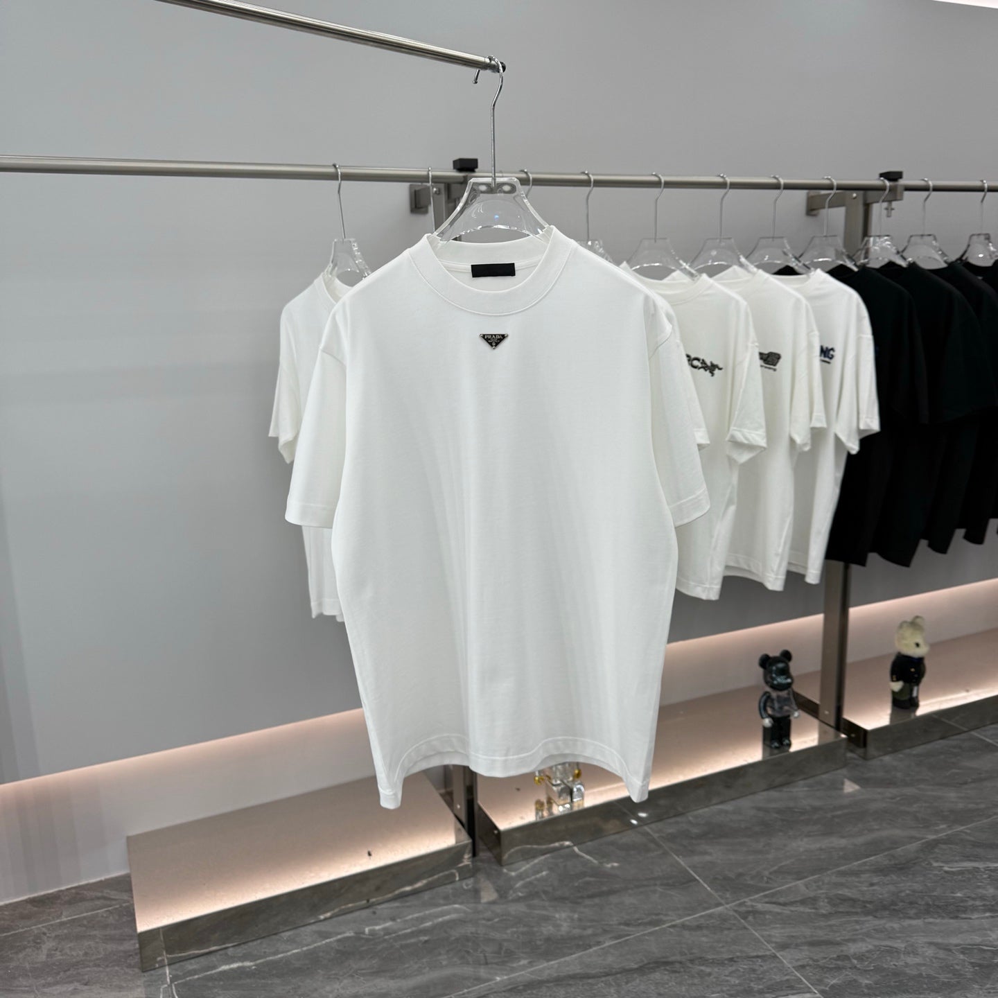 White short-sleeve T-shirt with Prada triangular logo and black stripe on chest