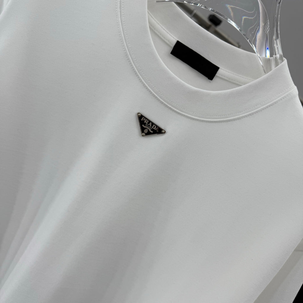 White T-shirt with Prada triangular metal logo pin on the chest