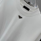 White T-shirt with Prada triangular metal logo pin on the chest