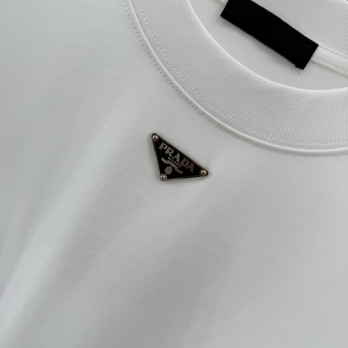 White T-shirt with small Prada triangular logo on the chest