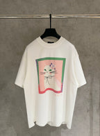 White short-sleeve T-shirt with colorful cat graphic and ribbon detail on front
