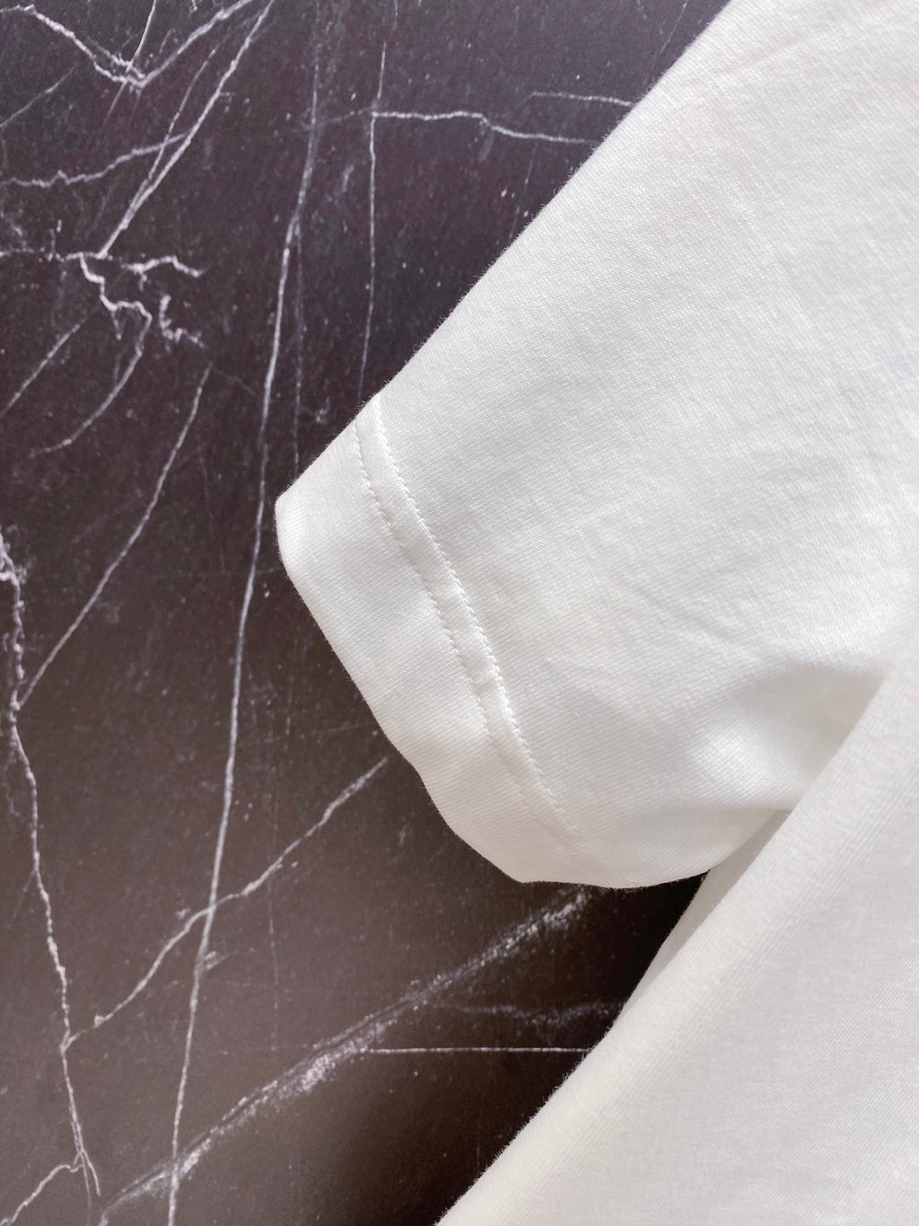Versace white T-shirt sleeve cuff close-up