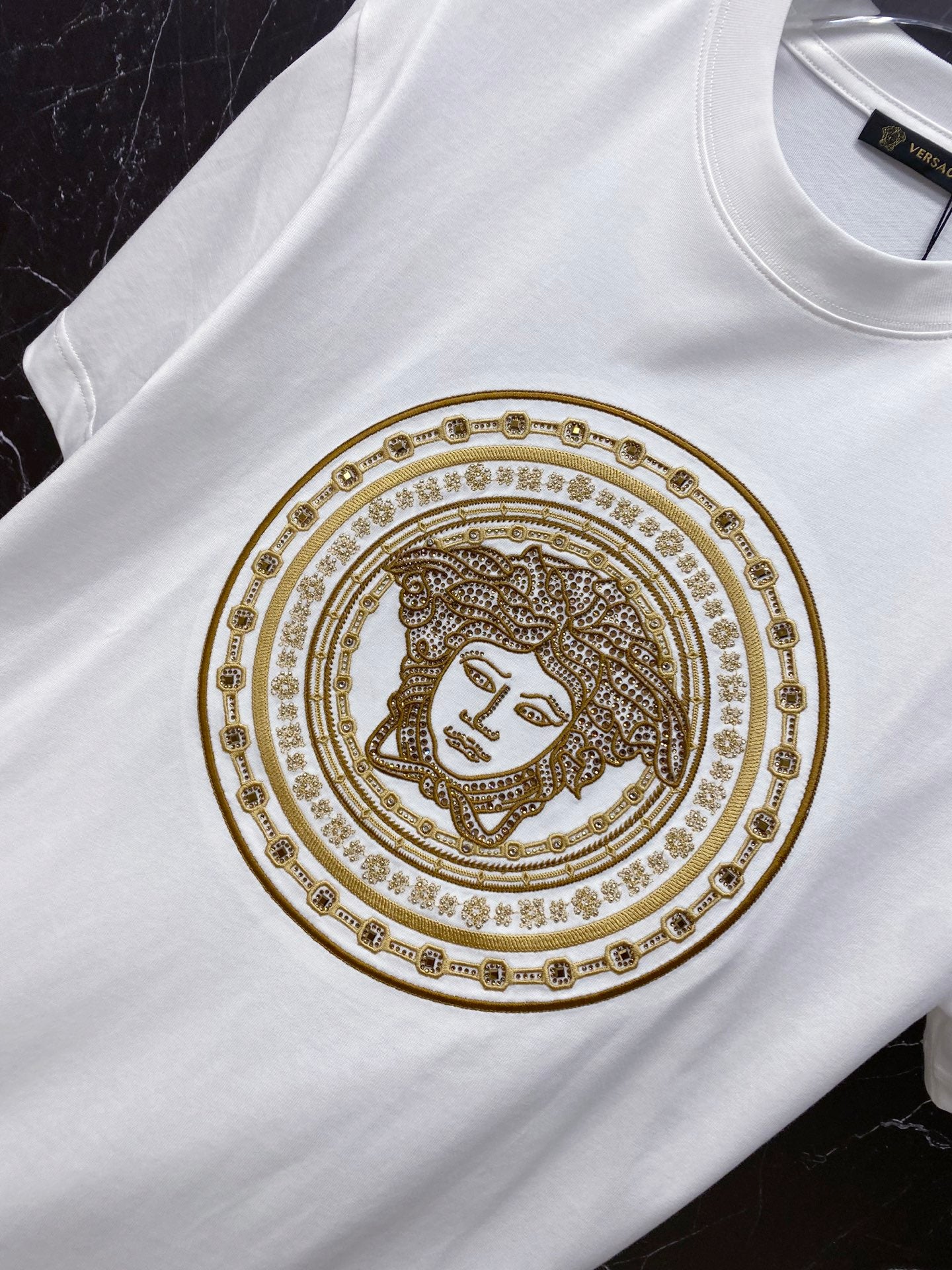 Versace white T-shirt with gold ornate medallion graphic and crew neckline