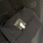 Black T-shirt sleeve fabric close-up with care label