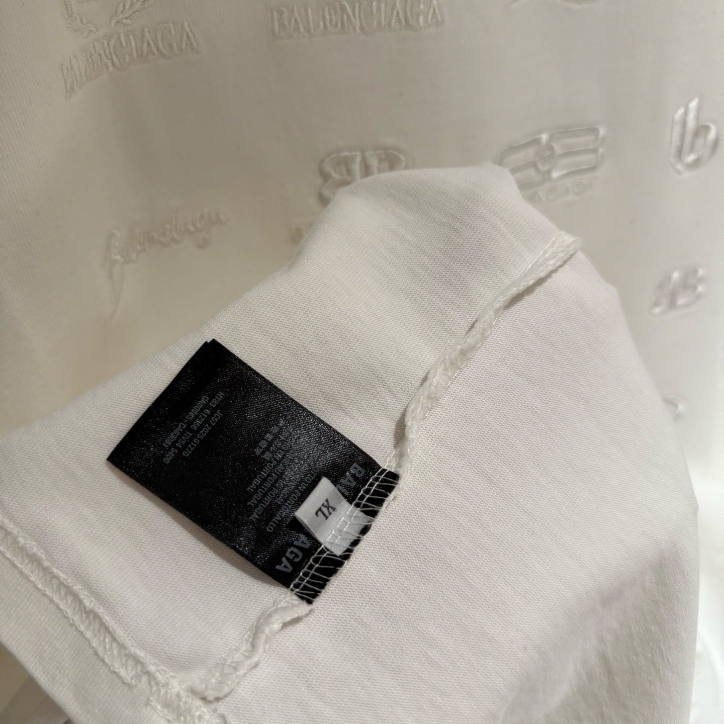 Balenciaga white T-shirt tag and label on the hem with embossed logo print