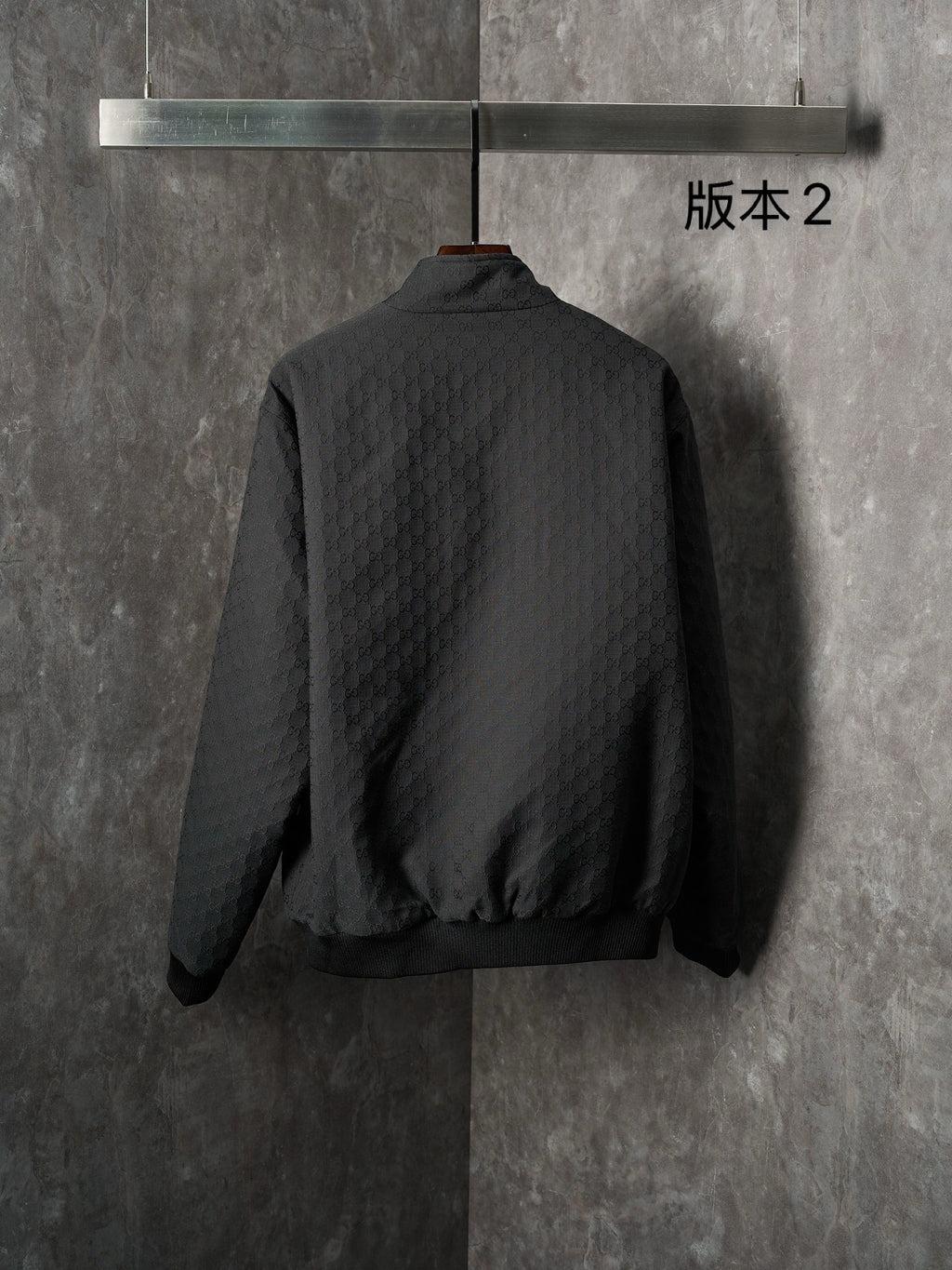 Long jacket, back view in dark allover GG pattern with center zipper