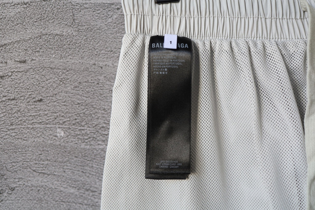 White pants with inner mesh fabric and size label tag near waistband