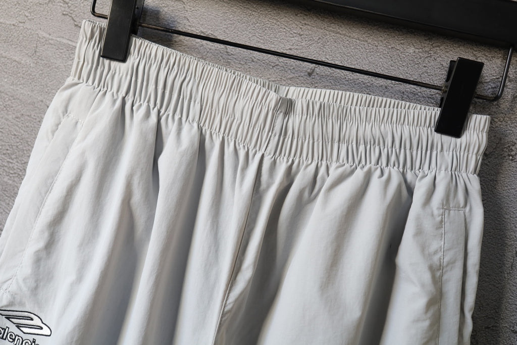 White pants with elastic waistband and wide pleated leg silhouette