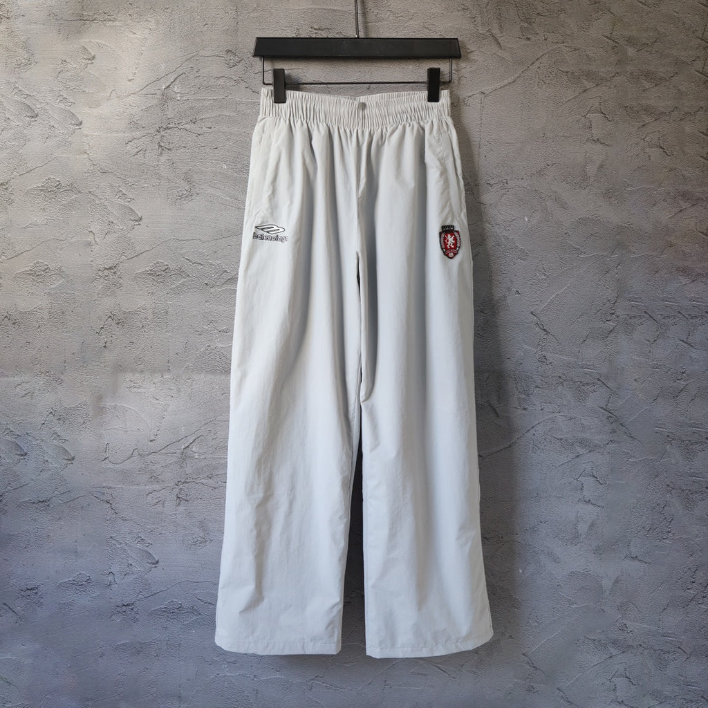 White wide-leg pants with elastic waistband and embroidered side logo patch