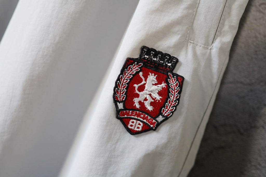 White pants with red and black embroidered crest logo patch
