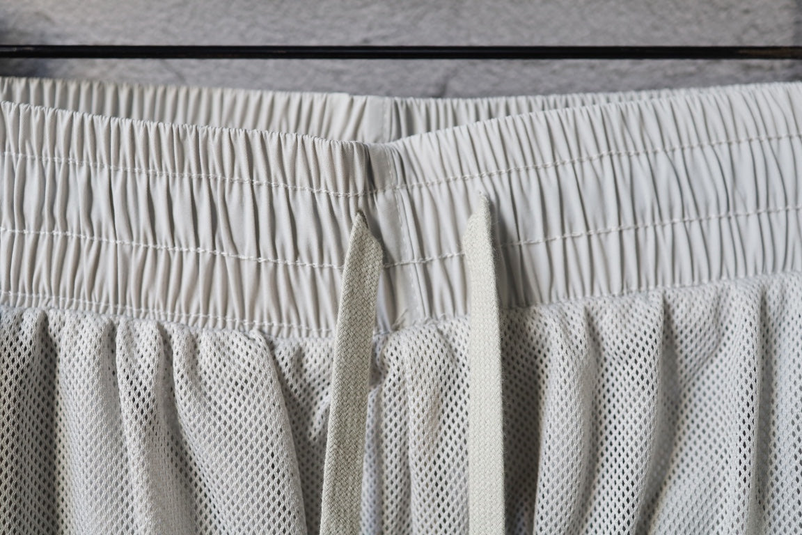 White pants waistband with elastic drawstring and textured mesh panel