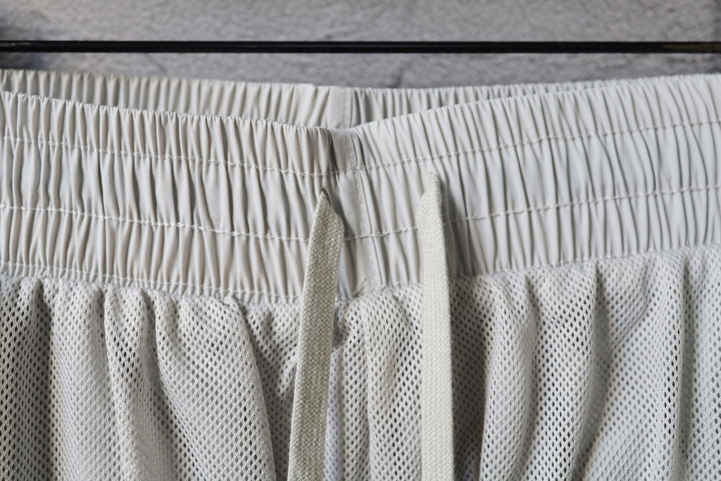 White pants with elastic waistband and textured mesh underlayer