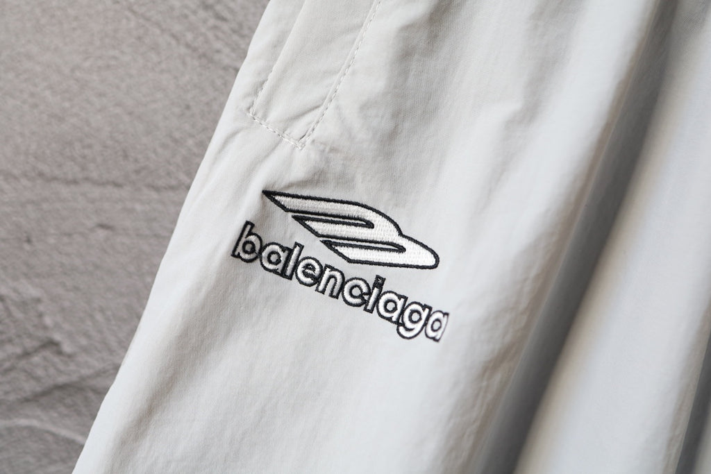 White pants with black Balenciaga logo print on the leg