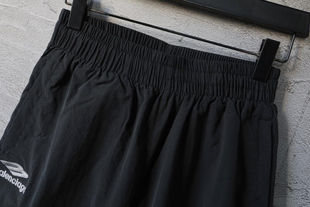 Black Balenciaga pants with gathered elastic waistband and front seams.