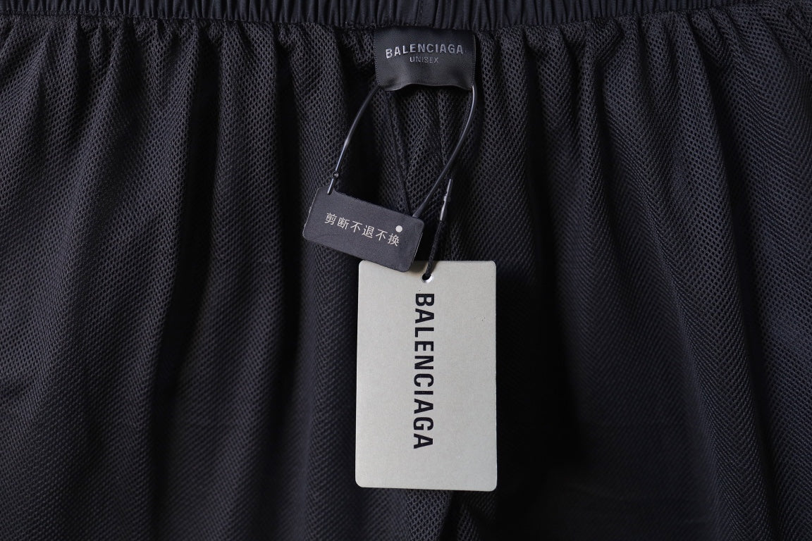 Black pants with mesh texture and hanging brand tag near the waistband