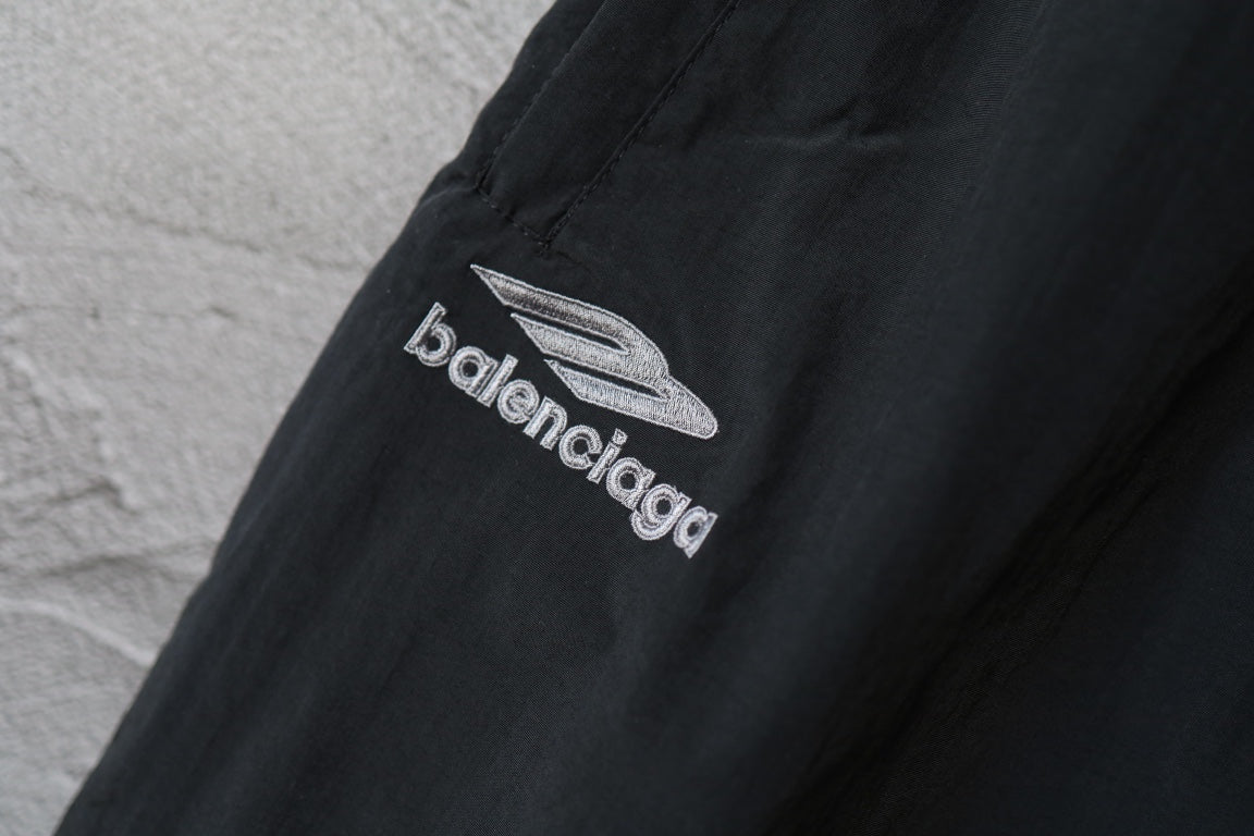 Black Balenciaga logo patch on front leg of pants.