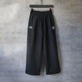 Black Balenciaga wide-leg pants with elastic waistband and side logo patch