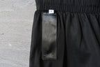 Black Balenciaga pants with interior size label tag visible near waistband.