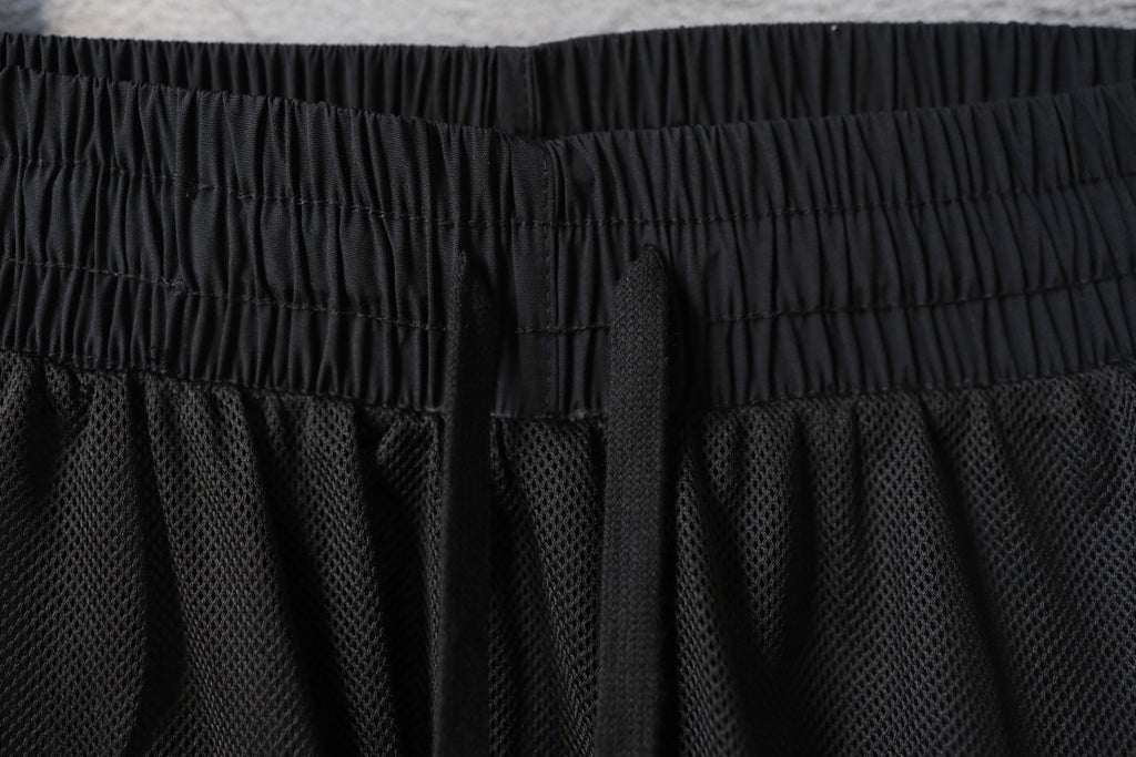 Black Balenciaga pants waistband with textured mesh panel below