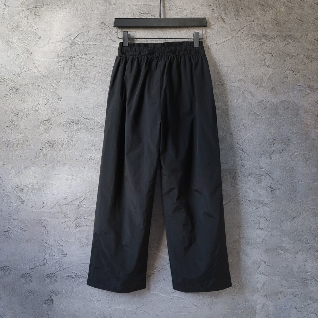 Black wide-leg pants with elastic waistband and subtle front logo detail