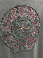 Close-up of ornate circular embroidery with red thread accents and gold-tone center