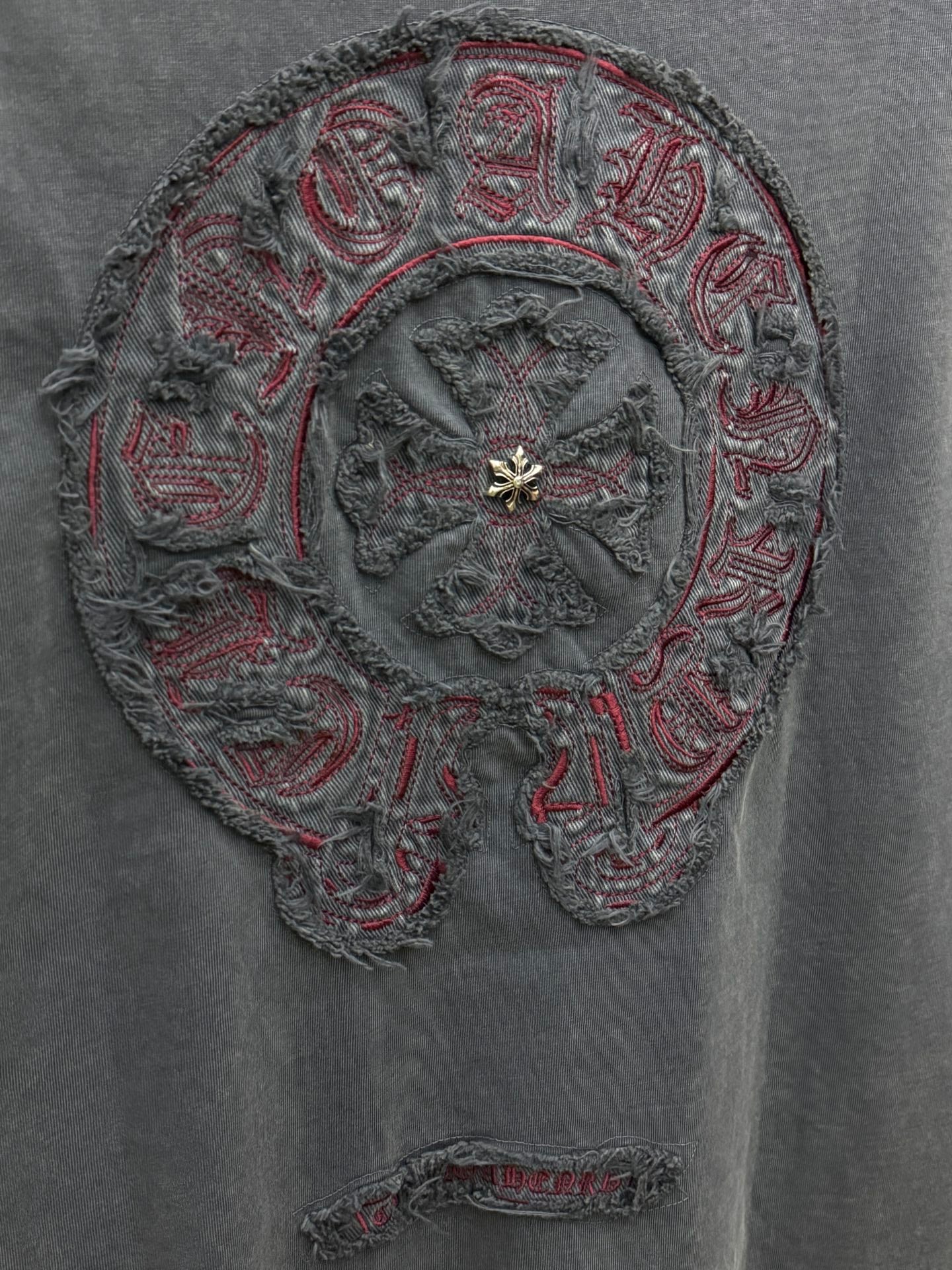 Close-up of large circular embroidery on T-shirt with gold-tone center detail