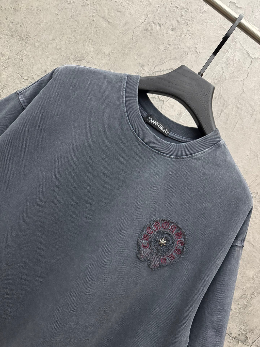 Graphic short-sleeve T-shirt close-up at collar with small chest circular embroidery