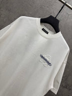 White short-sleeve T-shirt close-up at neckline with small blue logo embroidery on chest