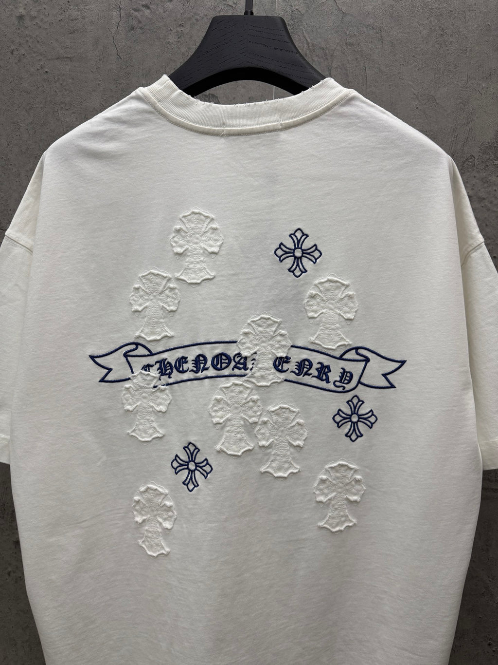 White short-sleeve T-shirt back view with blue banner text and raised snowflake appliques